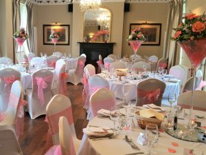 Pink themed wedding reception with champagne glass centre pieces, Greyhound Coaching Inn Lutterworth