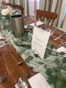 Room layout, unclothed trestle tables and floral decoration for all-inclusive wedding at The Greyhound Coaching Inn Lutterworth