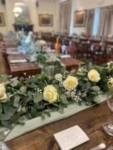Room layout, unclothed trestle tables and floral decoration for all-inclusive wedding at The Greyhound Coaching Inn Lutterworth